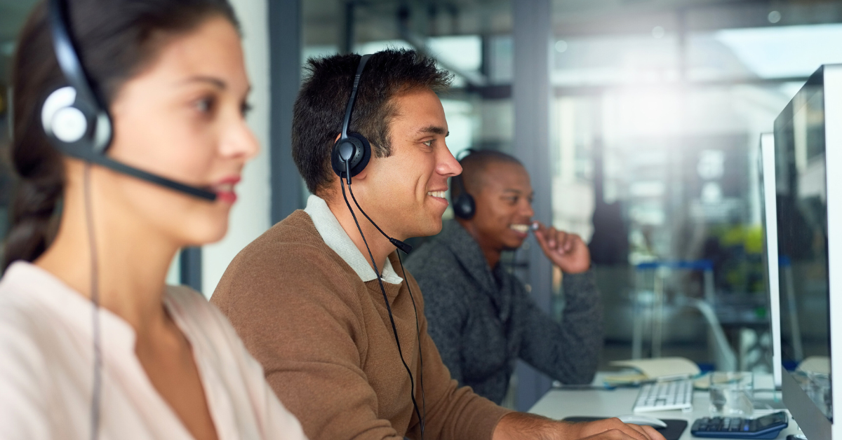 three Account managers smiling in their desk