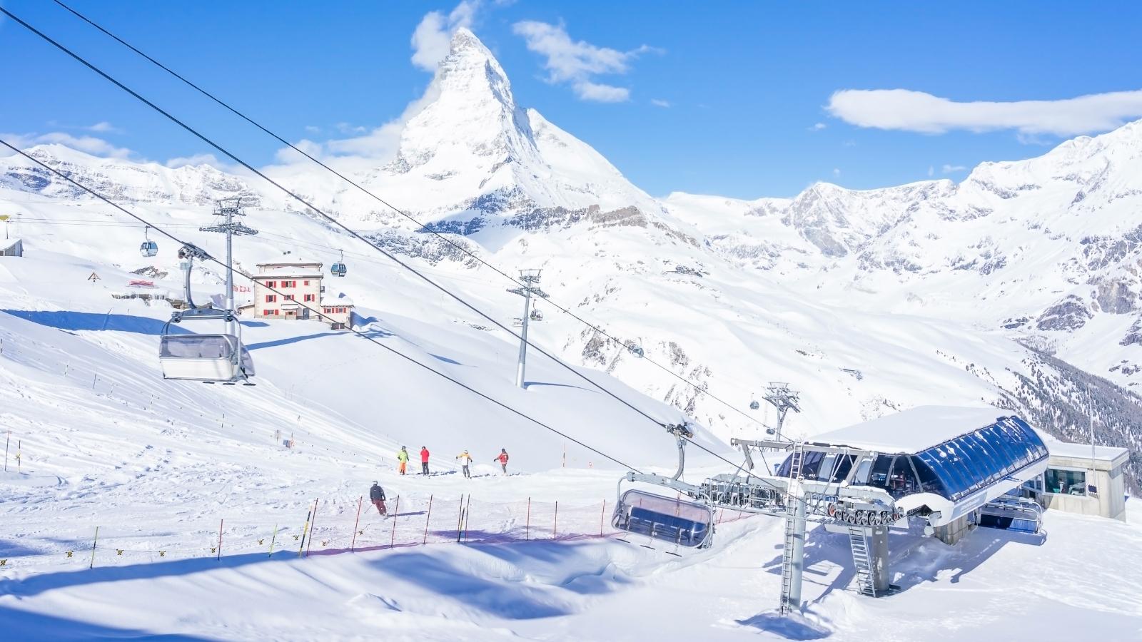 Skier in Cable car to Matterhorn Glacier Paradise with cloudy blue sky in cold summer day at Zermatt