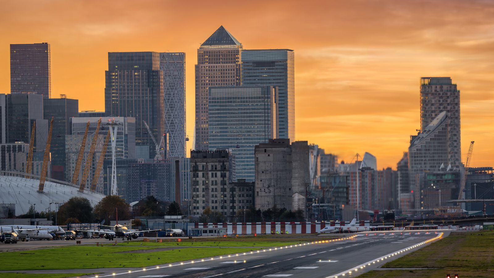 Panoramic view of the London skyline with Canary Wharf district and the runway of the City Airport