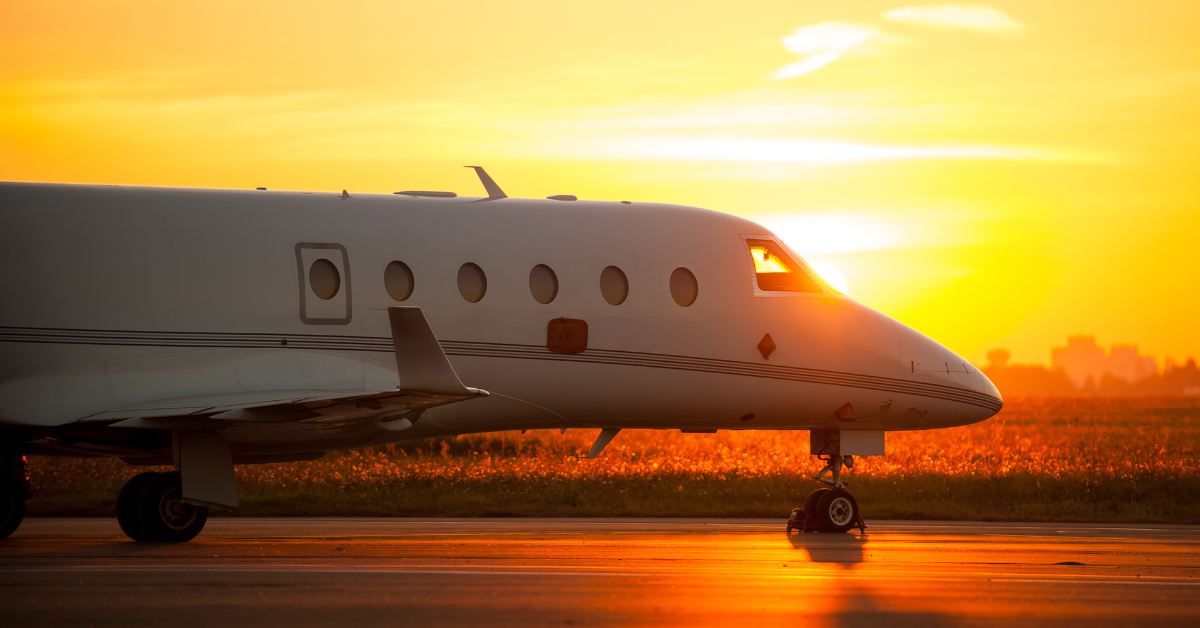 private jet charter parked, sunset in the backgrounf