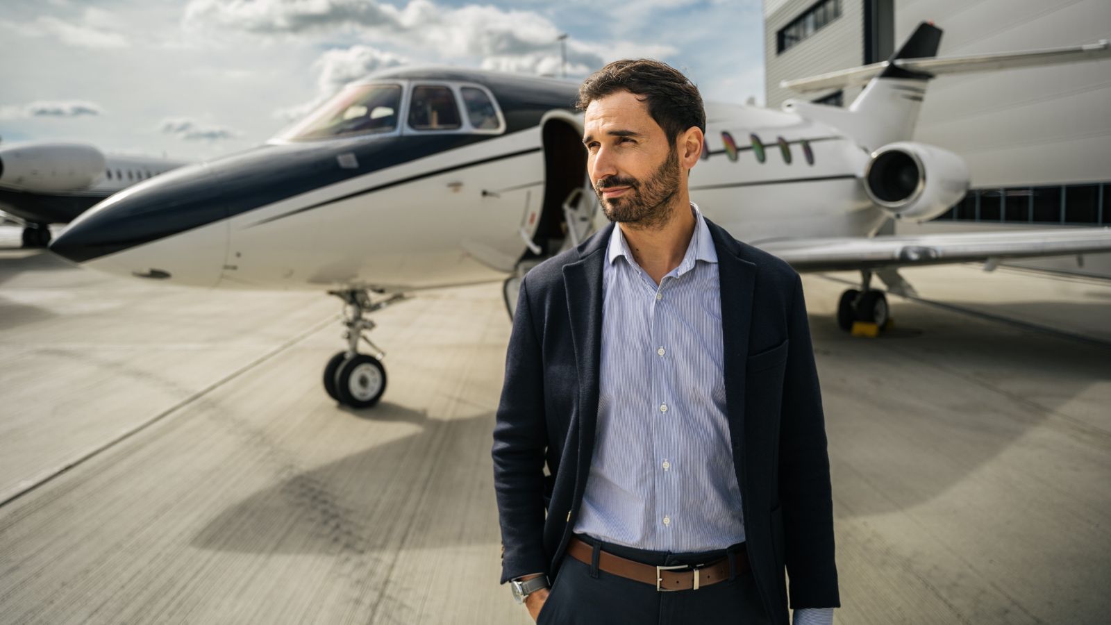 Well dressed man outside private jet