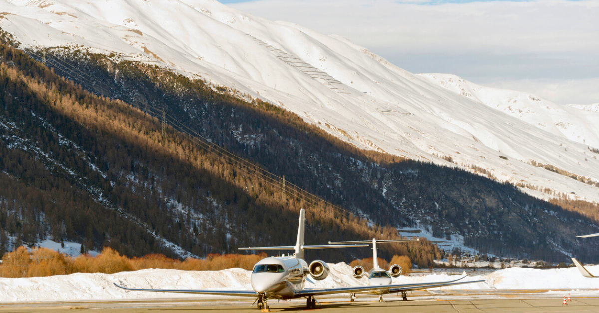 Two private jets on runaway with snowy mountains in the background