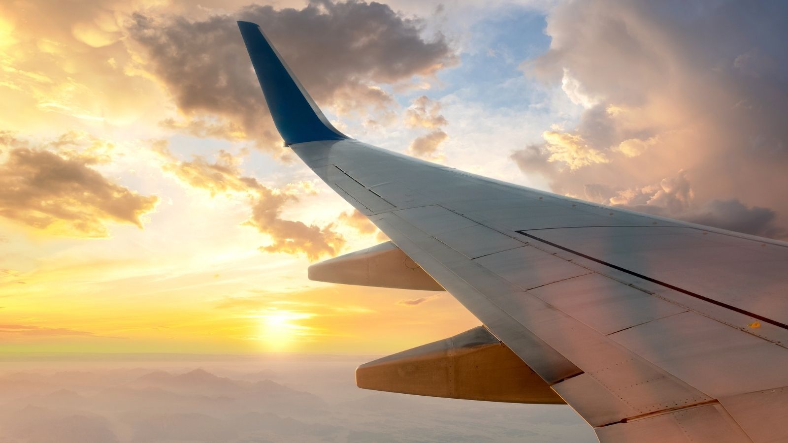 View from airplane on the aircraft white wing flying over desert landscape in sunny morning