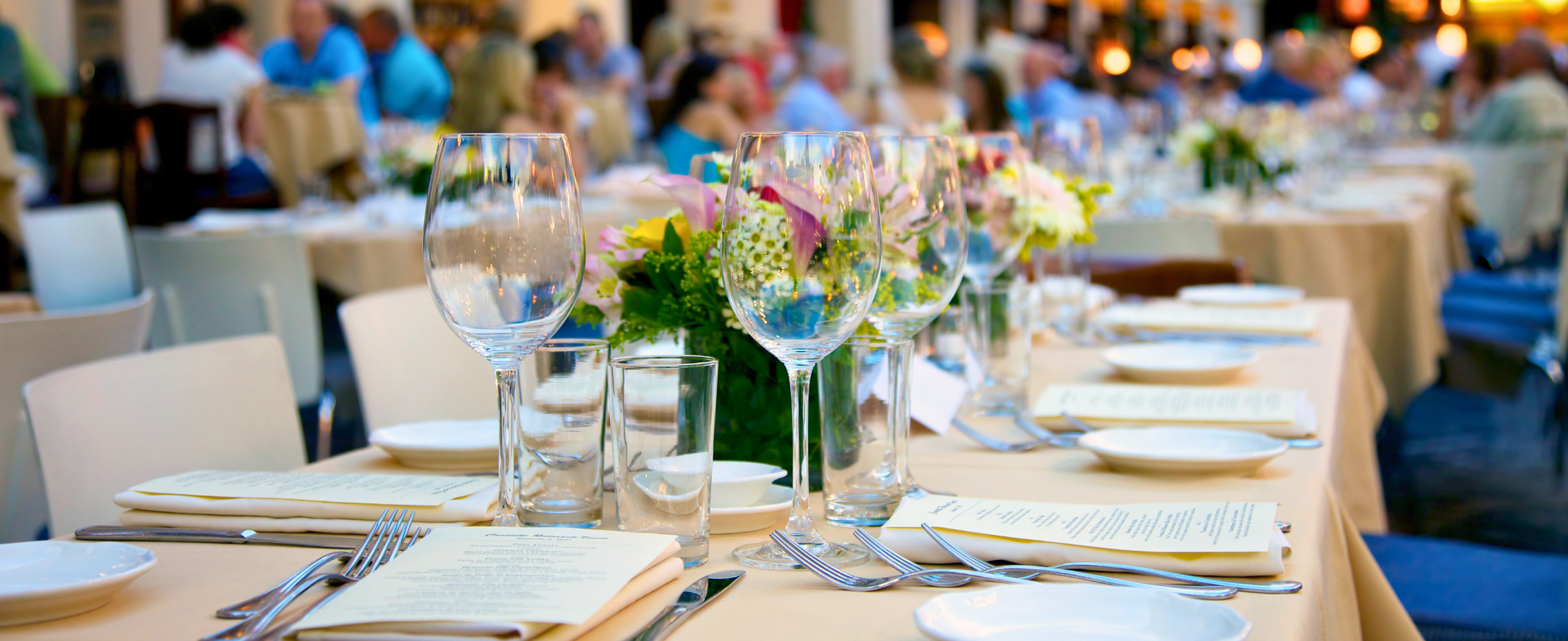 Professionally laid dining table with wine glasses and flowers